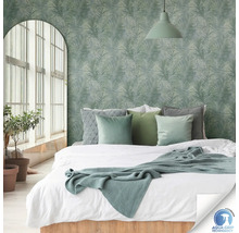 Slaapkamer met bed voor een muur met palmboommotieven