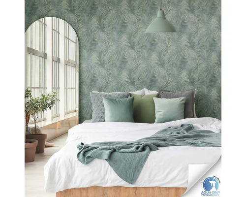 Slaapkamer met bed voor een muur met palmboommotieven