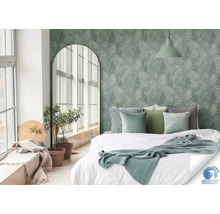 Slaapkamer met bed, kamerplanten en behang met bladmotief