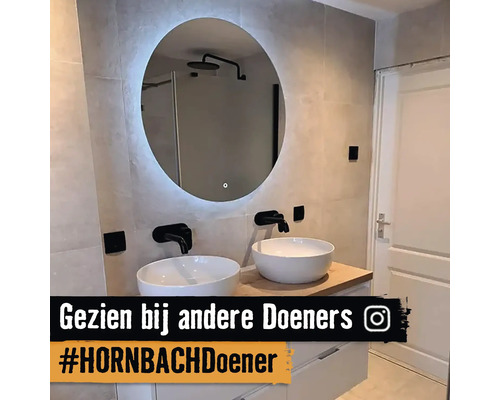 Badkamer met ronde spiegel, twee wastafels en armaturen