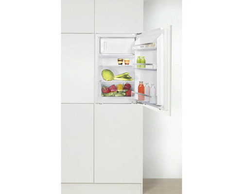 Geïntegreerde koelkast met open deur, gevuld met levensmiddelen.