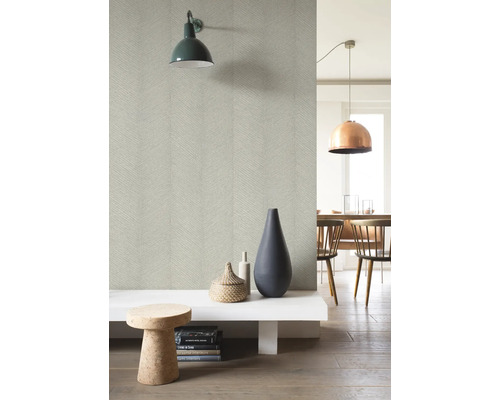 Lichte kamer met patroonbehang, wandlamp, decoraties en een eethoek op de achtergrond