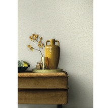 Scene met een beige wandachtergrond, een beige fluwelen bank, een dienblad, vazen en een bloem