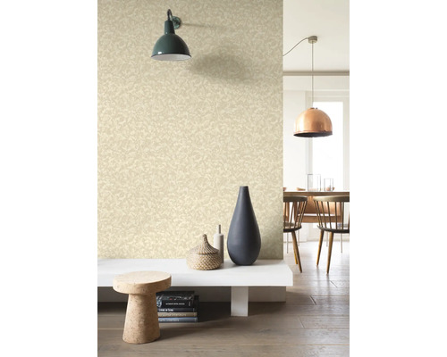 Woonkamer met patroonbehang, wandlamp en decoratieve elementen.