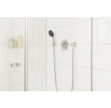 Douchecabine met handdouche en kraan op de witte betegelde muur