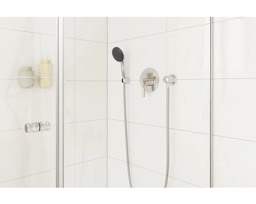 Douchecabine met handdouche en kraan op de witte betegelde muur