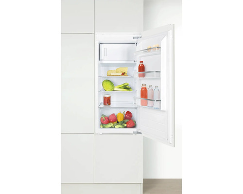 Geopende koelkast met boodschappen in een witte keuken