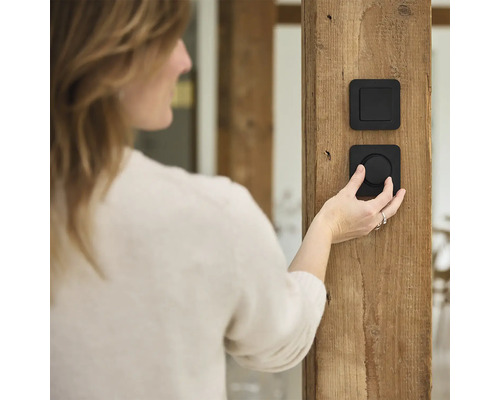 Vrouw bedient lichtschakelaar op houten paal