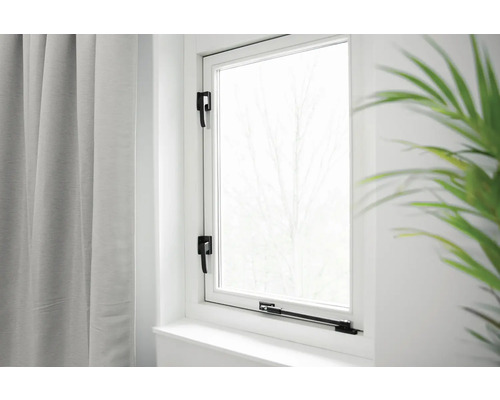 Wit raam met zwarte raamgrepen en gordijn