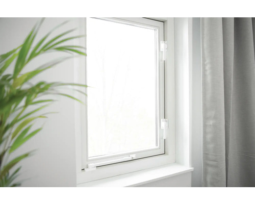 Gesloten wit raam met raamhendel in een lichte kamer.