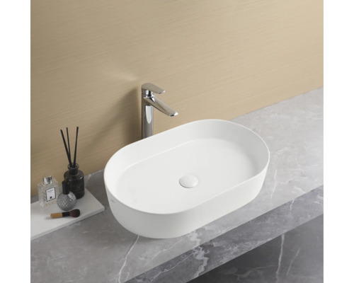 Ovale opzetwastafel met kraan op een aanrecht in de badkamer.