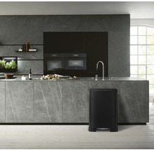 Moderne keuken met zwarte pedaalemmer, werkblad en inbouwapparatuur