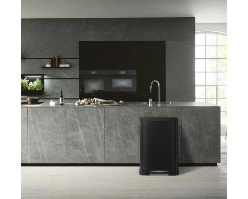 Moderne keuken met zwarte pedaalemmer, werkblad en inbouwapparatuur