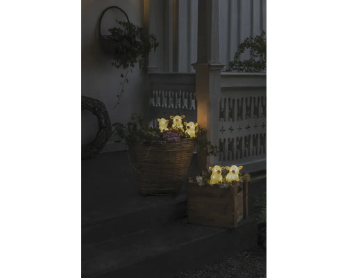 Decoratieve scène met verlichte koeienfiguren in manden op een trap