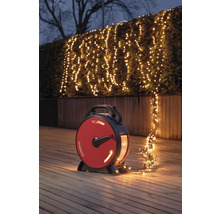 Scene met een lichtsnoer op een haspel die een struik in de tuin verlicht.