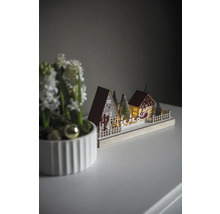 Decoratieve kerstscène met huizen, bomen en de slee van de kerstman