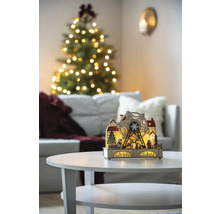 Decoratieve kerstverlichting met reuzenrad op een tafel in een woonkamer met kerstboom.