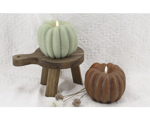 Decoratieve pompoen kaarsen op een houten kruk