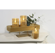 Decoratieve ledkaarsen in glazen houders op een houten dienblad met planten op een tafel