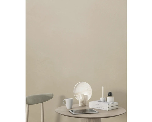 Decoratieve tafel met tablet, beker, boeken, kaars en decoratieve elementen voor een gekleurde wand