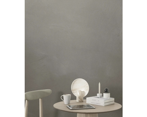 Scene met tafel, stoel, kop, tablet, kaars en decoratieve objecten tegen een grijze muur