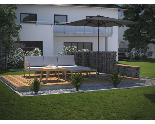 Terras met lounge meubilair, parasol en schanskorven in de tuin