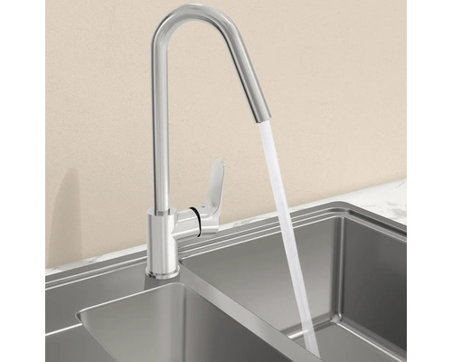 Roestvrijstalen keukenkraan met stromend water in een gootsteen