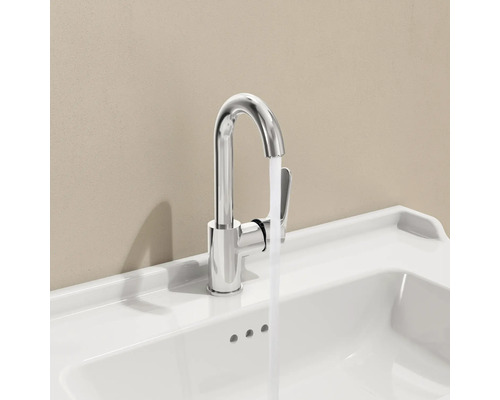 Verchroomde kraan op een witte wastafel met stromend water