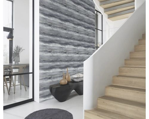 Lichte ruimte met patroonbehang, trap en bank