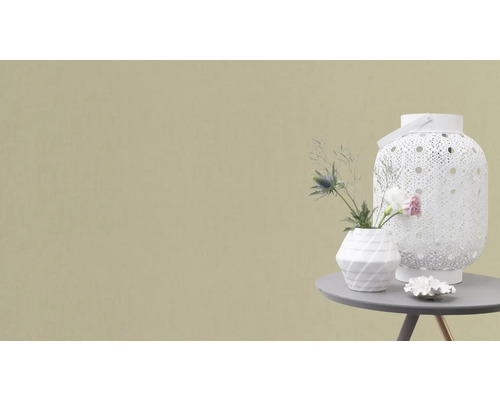 Decoratieve scène met lantaarn, vaas en bloemstuk op een tafel.