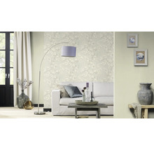 Woonkamer met bank, staande lamp en bloemenbehang voor een lichte sfeer