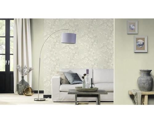 Woonkamer met bank, staande lamp en bloemenbehang voor een lichte sfeer