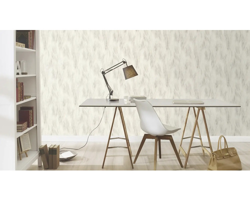 Scène van een werkkamer met behang met verenontwerp, bureau, lamp en boekenplank.