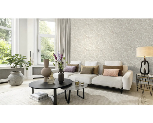 Lichte woonkamer met behang met motief, bank en salontafel.