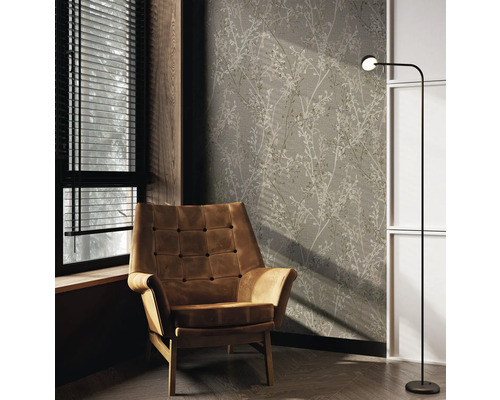 Woonkamer met fauteuil, staande lamp en bloemenbehang