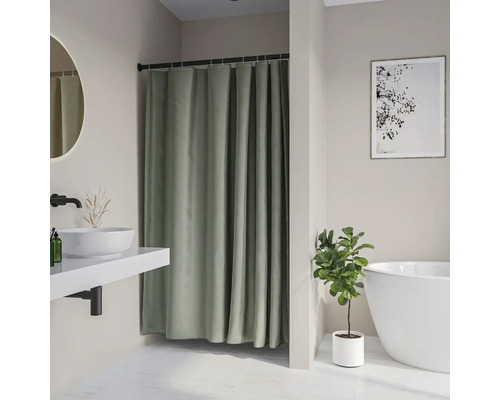 Badkamer met douchegordijn, wastafel, spiegel, bad, plant en fotolijst