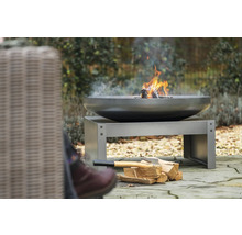 Vuurschaal met hout op een metalen sokkel in de tuin.