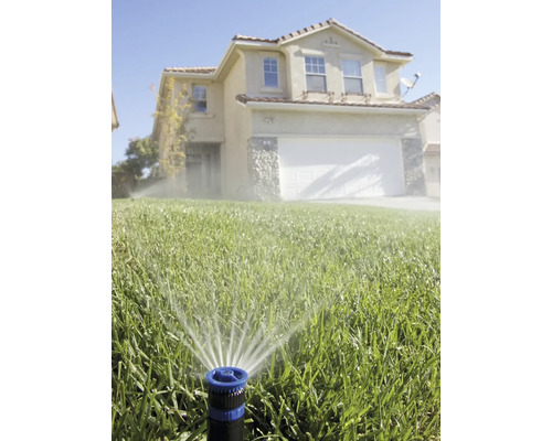 Gazonsproeier besproeit gazon voor woonhuis