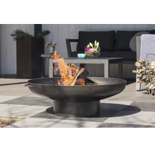 Metalen vuurschaal met hout en vlammen in de tuin