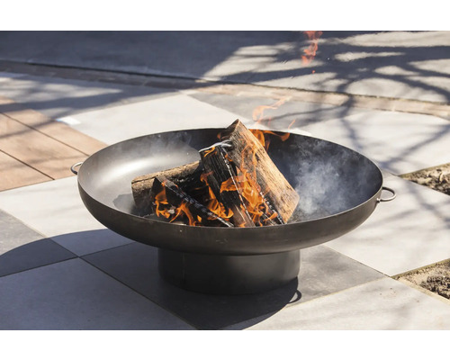 Vuur brandt in een ronde vuurschaal van metaal buitenshuis.