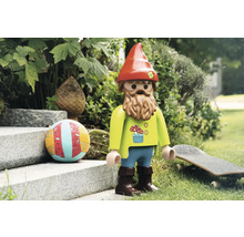 Speelgoedfiguur van een tuinkabouter met baard, muts en decoraties in de tuin