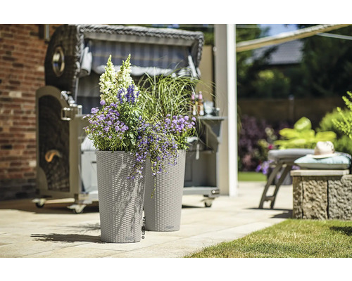 Twee plantenbakken met bloemen en een strandstoel op de achtergrond.