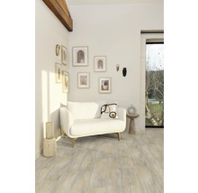 Woonkamer met witte bank, wanddecoraties en houten vloer