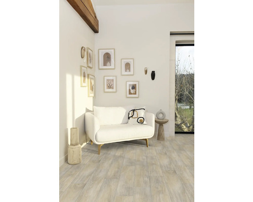 Woonkamer met witte bank, wanddecoraties en houten vloer