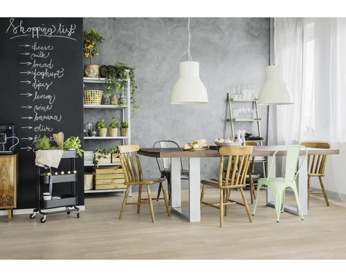 Lichte keuken met eettafel, stoelen, rek en schoolbord voor boodschappenlijstje.