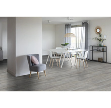 Lichte eetkamer met eettafel, stoelen en vloer in houtlook, evenals een fauteuil
