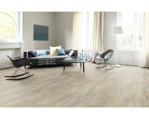 Lichte woonkamer met grijze bank, fauteuils, tafel en lichte vloerbedekking