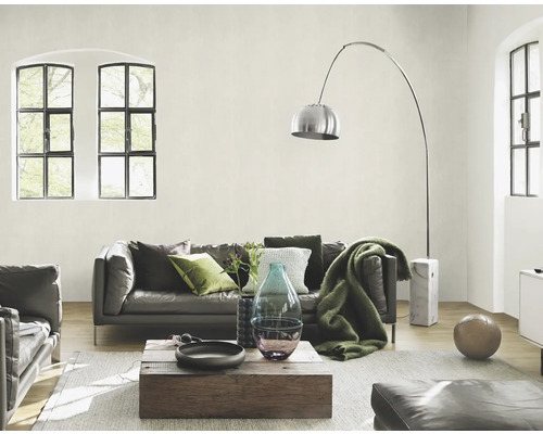 Woonkamer met leren bank, houten tafel, vloerlamp en grote ramen voor een heldere sfeer.