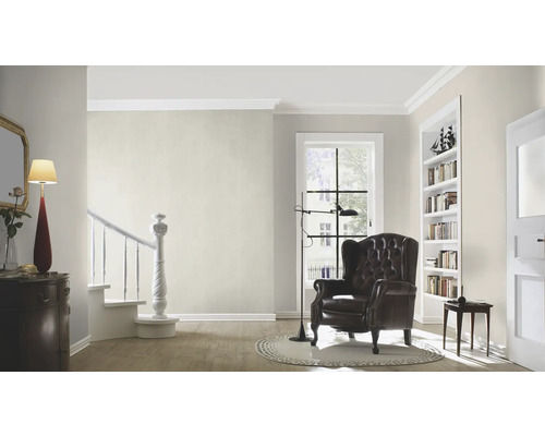 Woonkamer met fauteuil, lamp en boekenkast