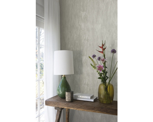 Decoratief interieur met patroonbehang, tafellamp, bloemen en boeken op een houten tafel
